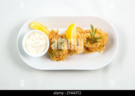 Ringe von Tintenfisch mit Zitrone auf weißem Hintergrund. Snack zu Bier. Draufsicht Stockfoto