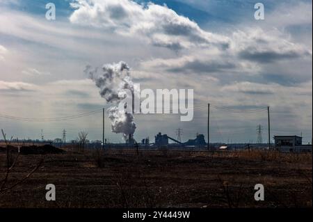 Eine Stahlfabrik in der Ferne unter dramatischem Himmel Stockfoto