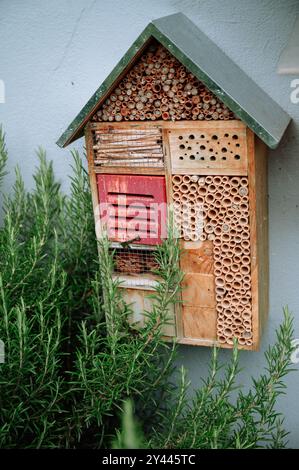 Handgefertigter Garten Wildbienenhaus umgeben von grünem Laub Stockfoto