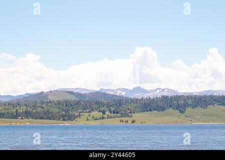 Ein friedlicher See mit bewaldeten Hügeln und fernen Bergen Stockfoto