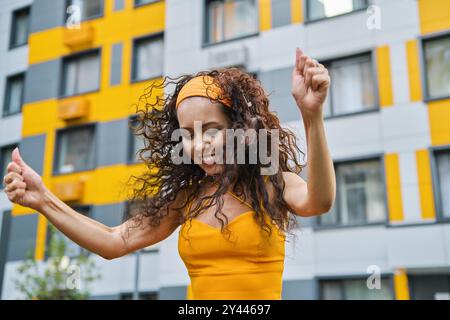 Fröhliche Frau, die in der Gasse tanzt Stockfoto