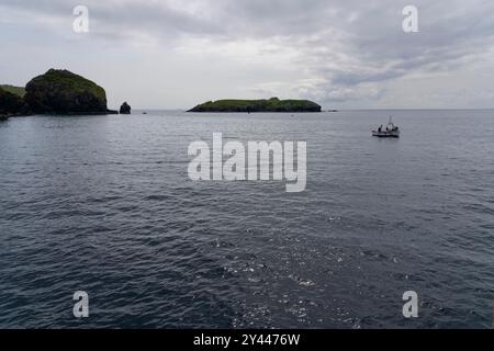 An einem bewölkten Julinachmittag treffen sich zwei kleine Fischerboote direkt vor dem Hafen von Mullion Cove. Stockfoto