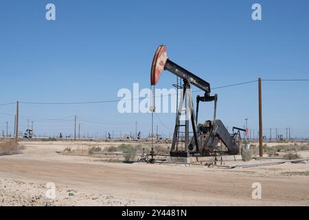 Ölderrick pumpt in einem trockenen, kargen Ölfeld in Zentralkalifornien Stockfoto