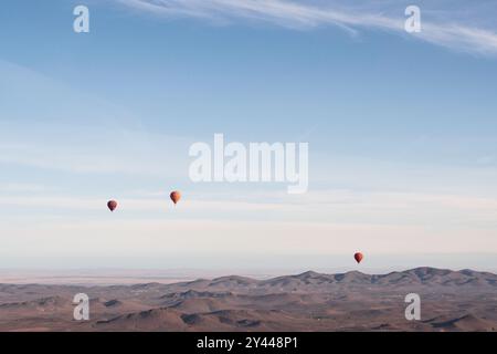 Mehrere Heißluftballons fliegen früh an einem Frühlingsmorgen über die Wüste Agafay in der Nähe von Marrakesch, Marokko. Stockfoto