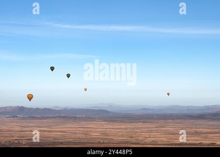 Mehrere Heißluftballons fliegen früh an einem Frühlingsmorgen über die Wüste Agafay in der Nähe von Marrakesch, Marokko. Stockfoto