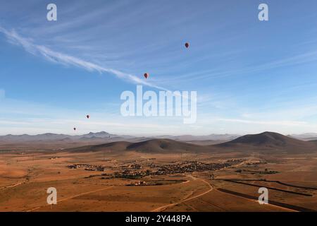 Mehrere Heißluftballons fliegen früh an einem Frühlingsmorgen über die Wüste Agafay in der Nähe von Marrakesch, Marokko. Stockfoto