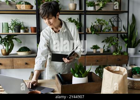 Eine Gärtnerin pflegt ihre Pflanzen und genießt ihren künstlerischen Arbeitsplatz. Stockfoto
