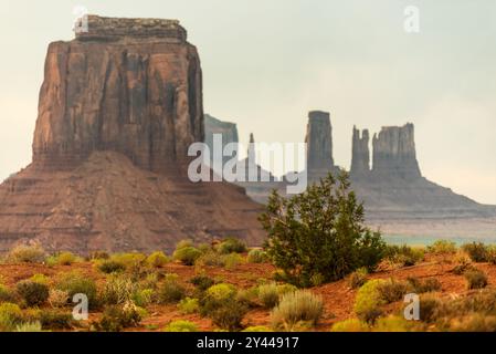 Im Monument Valley erheben sich berühmte rote Felsenbänke über Wüstensträucher Stockfoto