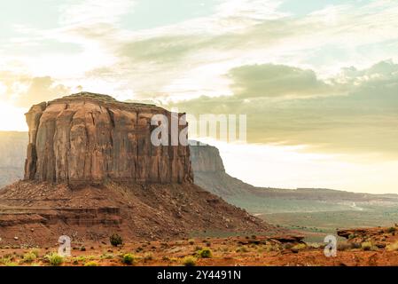Monument Valley mesa bei Sonnenaufgang, in goldenes Licht getaucht Stockfoto