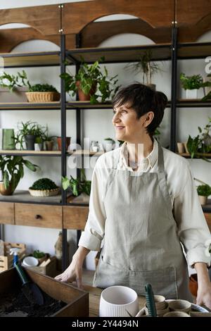 Ein Gärtner, der ihre geliebten Pflanzen in einem gemütlichen Atelier pflegt. Stockfoto