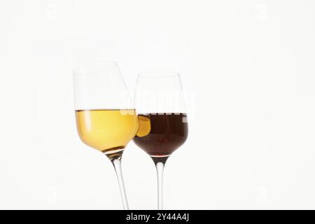 Klirrende Gläser an dünnen Stielen mit Rot- und Weißwein. Stockfoto