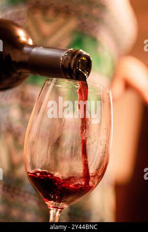 Ein Glas Rotwein wird aus einer Flasche gegossen Stockfoto