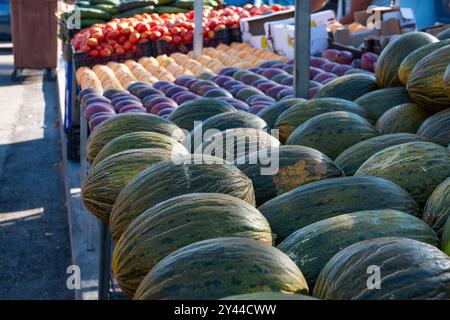 Verschiedene Obst- und Gemüsesorten werden auf einem beliebten Markt ausgestellt. Von Melonen, Pfirsichen oder Mangos bis hin zu Knoblauch oder Zwiebeln Stockfoto