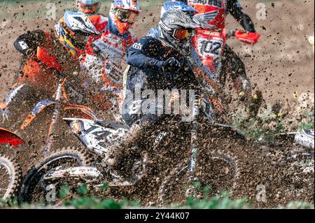 Agios Sozomenos, Zypern - 11. Februar 2024: Motocross-Fahrer sind im Schlamm, während sie an einem Meisterschaftsrennen teilnehmen, umgeben von anderen Rennern Stockfoto