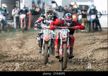 Agios Sozomenos, Zypern - 11. Februar 2024: Zwei Motocross-Rennfahrer fahren während der zyprischen MX-Pro-Meisterschaft durch eine matschige Kurve Stockfoto