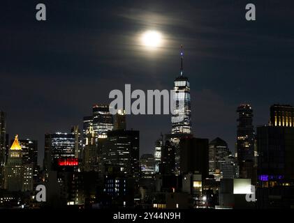 New York, Usa. September 2024. Am Montag, den 16. September 2024, untergeht ein zu 96 % gewachsener Mond hinter dem One World Trade Center und der Skyline von Manhattan in New York City. Foto: John Angelillo/UPI Credit: UPI/Alamy Live News Stockfoto