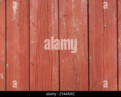 Die in schwedischem Rot gemalte Holzwand ist eine traditionelle Farbe, die häufig auf skandinavischen Fassaden zu finden ist und eine inspirierende und unverwechselbare Ästhetik bietet. Stockfoto