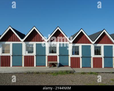 Reihe schwedischer Strandhäuser in typischer Holzkonstruktion und schwedischen Farben. Sie sind sehr attraktive und malerische Touristenattraktionen. Stockfoto
