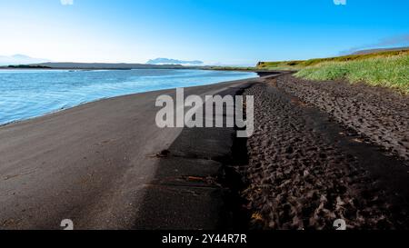 Schwarzer Strand mit Fußspuren und Kieselsteinen auf der Halbinsel Vatnsnes in Nordisland Stockfoto