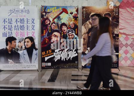 Fuyang, China. September 2024. Die Leute laufen am 16. September 2024 in einem Kino in Fuyang, China, vorbei an Filmplakaten. (Foto: Costfoto/NurPhoto) Credit: NurPhoto SRL/Alamy Live News Stockfoto