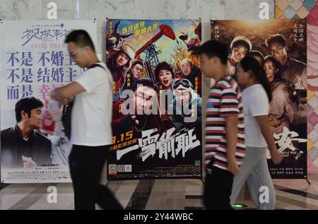 Fuyang, China. September 2024. Die Leute laufen am 16. September 2024 in einem Kino in Fuyang, China, vorbei an Filmplakaten. (Foto: Costfoto/NurPhoto) Credit: NurPhoto SRL/Alamy Live News Stockfoto