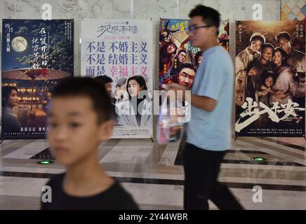 Fuyang, China. September 2024. Die Leute laufen am 16. September 2024 in einem Kino in Fuyang, China, vorbei an Filmplakaten. (Foto: Costfoto/NurPhoto) Credit: NurPhoto SRL/Alamy Live News Stockfoto