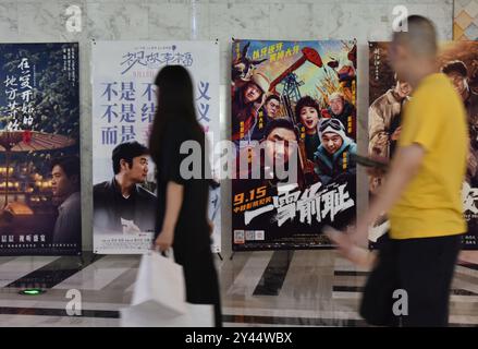 Fuyang, China. September 2024. Die Leute laufen am 16. September 2024 in einem Kino in Fuyang, China, vorbei an Filmplakaten. (Foto: Costfoto/NurPhoto) Credit: NurPhoto SRL/Alamy Live News Stockfoto