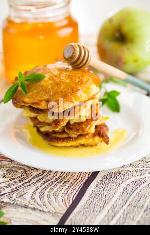 Gebratene Pfannkuchen mit Äpfeln und Honig. Stockfoto