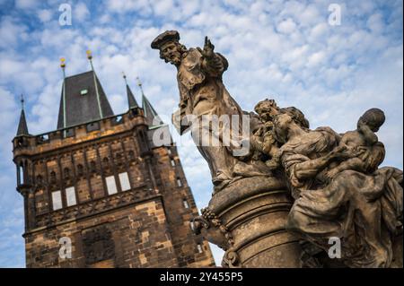Statue des Heiligen Ivo von Kermartin und alter Turm an der Karlsbrücke in Prag Stockfoto