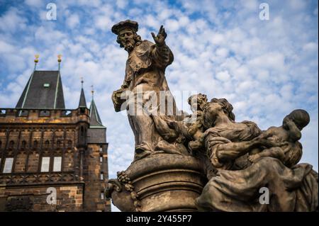 Statue des Heiligen Ivo von Kermartin und alter Turm an der Karlsbrücke in Prag Stockfoto