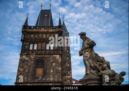 Statue des Heiligen Ivo von Kermartin und alter Turm an der Karlsbrücke in Prag Stockfoto