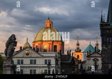 Blick auf die Kirche St. Franziskus von Assisi und die Skyline der Stadt bei Sonnenuntergang von der Karlsbrücke in Prag Stockfoto