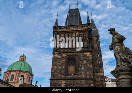 Statue des Heiligen Ivo von Kermartin und alter Turm an der Karlsbrücke in Prag Stockfoto