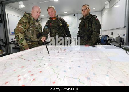 16. September 2024, Bayern, Kümmersbruck: Generalleutnant Jürgen-Joachim von Sandrart (M), Kommandeur des multinationalen NATO-Korps Northeast, spricht mit Brigadegeneral Andrew Bates (l) der US-Streitkräfte und Brigadegeneral Tomasz Kowalik (r) der polnischen Armee im mobilen Kommandoposten. Soldaten aus zahlreichen NATO-Ländern - darunter Estland, Frankreich, Deutschland, Großbritannien, Italien, Lettland, Litauen, die Niederlande, Polen, Spanien und die USA nehmen an der NATO-Kommandostellenübung Avenger Triad 24 Teil. Die Übung findet vom 9. Bis 19. September an verschiedenen Orten statt Stockfoto