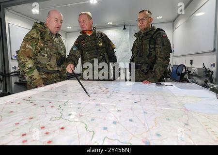 16. September 2024, Bayern, Kümmersbruck: Generalleutnant Jürgen-Joachim von Sandrart (M), Kommandeur des multinationalen NATO-Korps Northeast, spricht mit Brigadegeneral Andrew Bates (l) der US-Streitkräfte und Brigadegeneral Tomasz Kowalik (r) der polnischen Armee im mobilen Kommandoposten. Soldaten aus zahlreichen NATO-Ländern - darunter Estland, Frankreich, Deutschland, Großbritannien, Italien, Lettland, Litauen, die Niederlande, Polen, Spanien und die USA nehmen an der NATO-Kommandostellenübung Avenger Triad 24 Teil. Die Übung findet vom 9. Bis 19. September an verschiedenen Orten statt Stockfoto