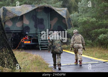 16. September 2024, Bayern, Kümmersbruck: Zwei Soldaten nähern sich dem mobilen Kommandoposten. Während des Medientages für die NATO-Kommandoposten-Übung Avenger Triad 24 wurde innerhalb von 24 Stunden eine komplette mobile Kommandozentrale mit einem mobilen Kommandoposten von einer Kaserne in das Militärübungsgebiet Kümmersbruck verlegt. Soldaten aus zahlreichen NATO-Ländern nehmen an der Übung Teil - darunter Estland, Frankreich, Deutschland, Großbritannien, Italien, Lettland, Litauen, die Niederlande, Polen, Spanien und die USA. Die Übung findet vom 9. Bis 19. September an verschiedenen Standorten in Europa statt. Foto: Daniel Stockfoto