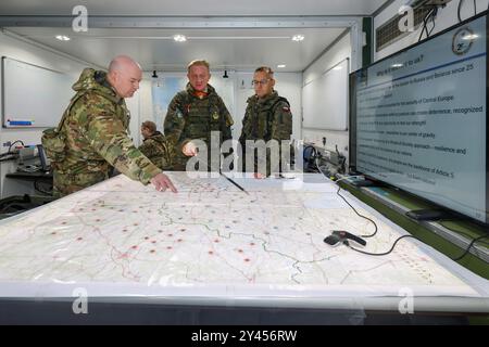 16. September 2024, Bayern, Kümmersbruck: Generalleutnant Jürgen-Joachim von Sandrart (M), Kommandeur des multinationalen NATO-Korps Northeast, spricht mit Brigadegeneral Andrew Bates (l) der US-Streitkräfte und Brigadegeneral Tomasz Kowalik (r) der polnischen Armee im mobilen Kommandoposten. Soldaten aus zahlreichen NATO-Ländern - darunter Estland, Frankreich, Deutschland, Großbritannien, Italien, Lettland, Litauen, die Niederlande, Polen, Spanien und die USA nehmen an der NATO-Kommandostellenübung Avenger Triad 24 Teil. Die Übung findet vom 9. Bis 19. September an verschiedenen Orten statt Stockfoto