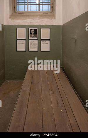 Innere einer kleinen Haftzelle im "Bunker" des KZ Buchenwald mit Bett und Porträt und Namen der Opfer Stockfoto