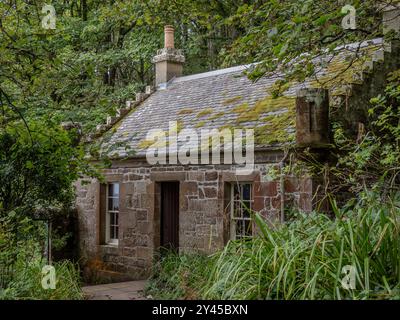 Nahaufnahme eines alten Steinhauses umgeben von Grün tief in einem abgelegenen, üppigen Waldgebiet auf Culzean Castle Anwesen in Schottland Stockfoto