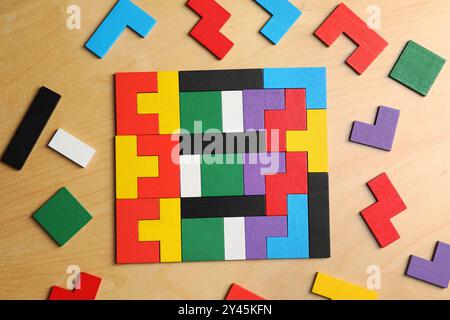 Bunte Puzzleteile auf Holztisch, flache Lagen Stockfoto