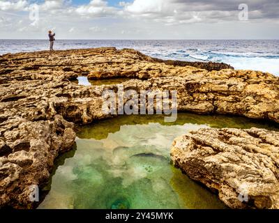 Mann, der ein Bild steht auf dem Corallium Kalkstein Pflaster in der Nähe von The Azure Window - Insel Gozo, Malta Stockfoto