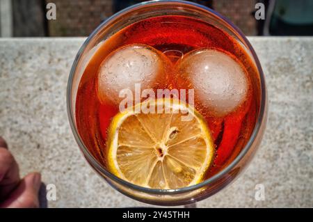 Aperol Spritz Cocktail von oben gesehen, mit Eis und Zitrone, die ein gruseliges Gesicht bilden Stockfoto