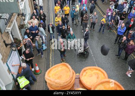 8. September 2024. Ramsbottom, Bury, Lancashire UK. Die Weltmeisterschaft Im Schwarzen Pudding-Werfen. Die Teilnehmer stehen auf einem „goldenen Gitter“, das feierlich auf die Bridge Street im Dorf Ramsbottom geführt und an der Tür des Oaks Public House platziert wird. Die Teilnehmer stehen mit einem Fuß auf der Startaufstellung, und mit einem „Lob“ unter den Armen schleudern 3 schwarze Puddings von Chadwicks of Bury auf 12 Yorkshire Puddings auf einem Sockel 30 Fuß/6 Meter hoch auf einem Gerüst. Der Sport steht für die Rivalität zwischen den benachbarten englischen Countys Lancashire und Yorkshire, die auf den Krieg zurückgeht Stockfoto