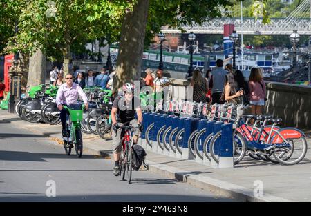 London, Großbritannien. Radfahrer radeln an Reihen von Leihfahrrädern am Victoria Embankment in der Nähe von Parliament, Westminster Stockfoto