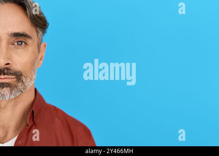 Ernster Mann mittleren Alters isoliert auf blauem Hintergrund. Nahaufnahme des Halbgesichts im Porträt Stockfoto