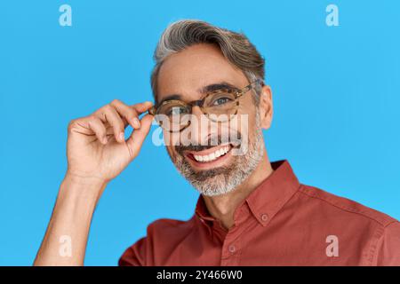Glücklicher reifer Mann mit stilvoller Brille isoliert auf blauem Hintergrund. Stockfoto