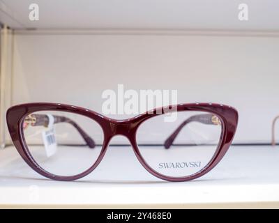 Burgundy swarovski Katzenaugenbrille mit klaren Gläsern auf weißem Regal im Geschäft Stockfoto