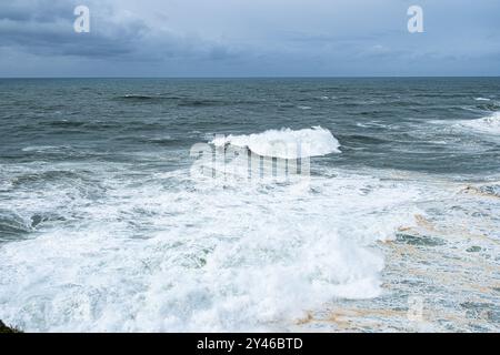 Große Wellen in der Nähe des Leuchtturms in Praia do Norte, Nazare in Portugal Stockfoto