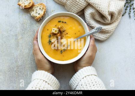 Eine Frau, die eine Schüssel mit Kürbissuppe hält. Kopierbereich. Stockfoto