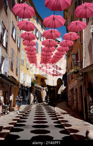 Pinkfarbene Regenschirme schmücken die Straßen von Grasse in Frankreich Stockfoto